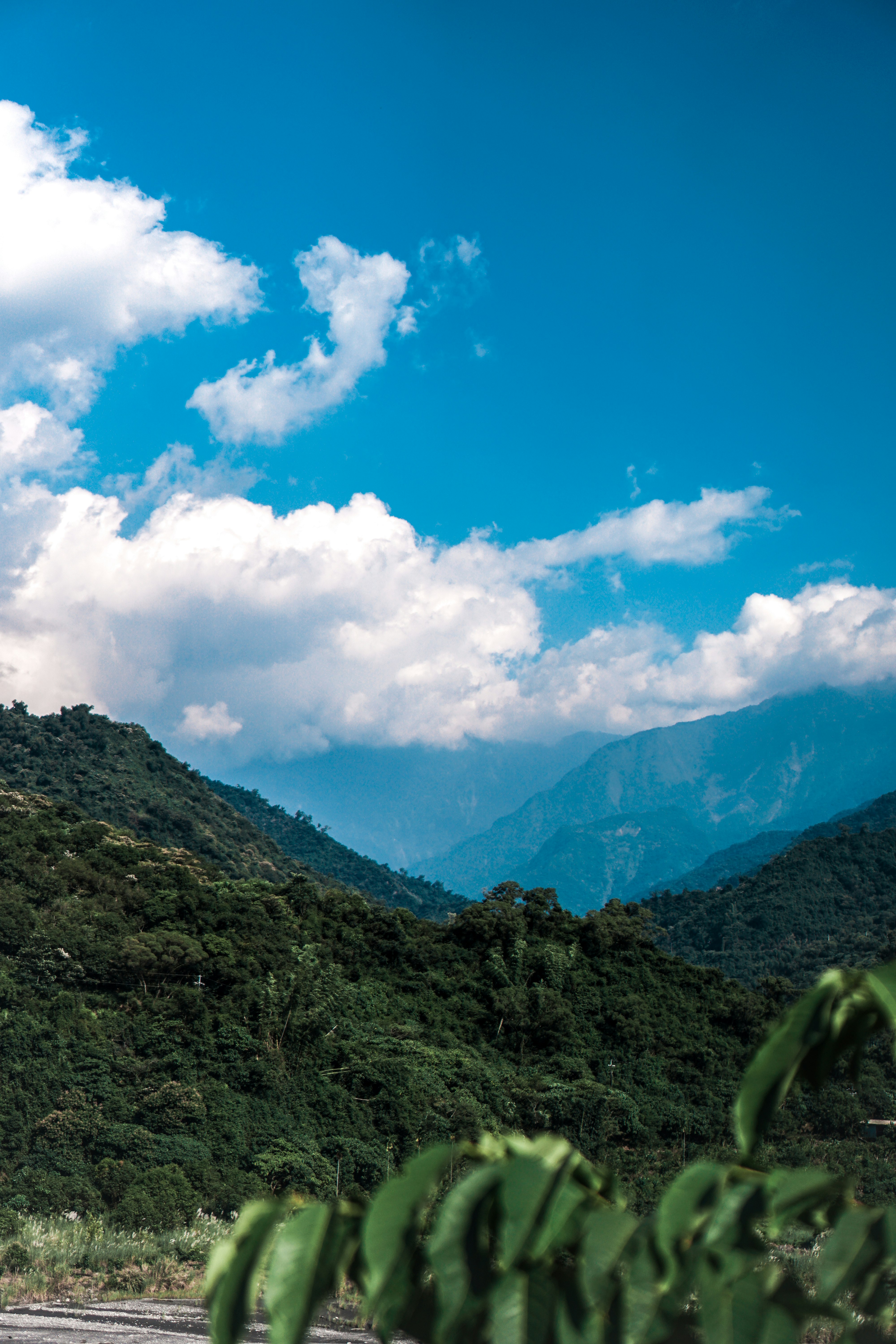 green mountain under blue sky and white clouds during daytime